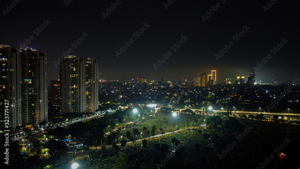 Modern buildings of Jakarta with lights at night on background, view from Kuningan Jakarta, Indonesia