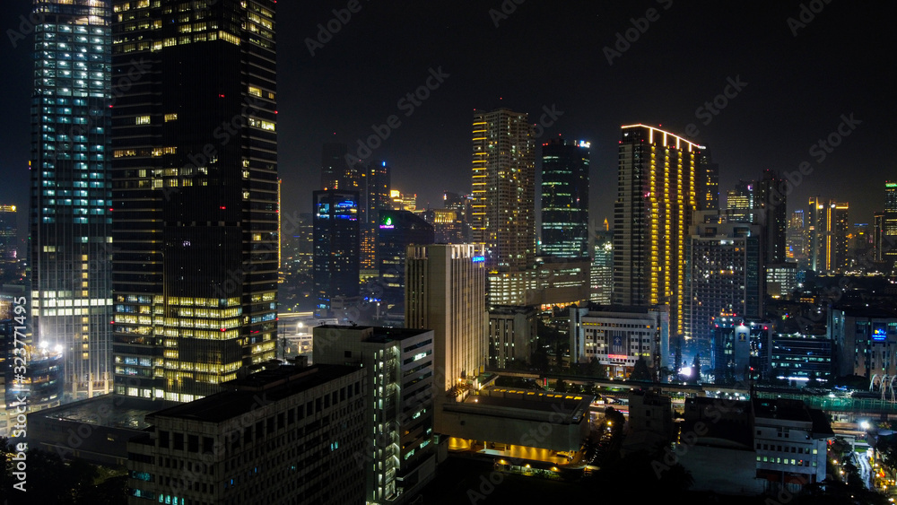 Modern buildings of Jakarta with lights at night on background, view from Kuningan Jakarta, Indonesia