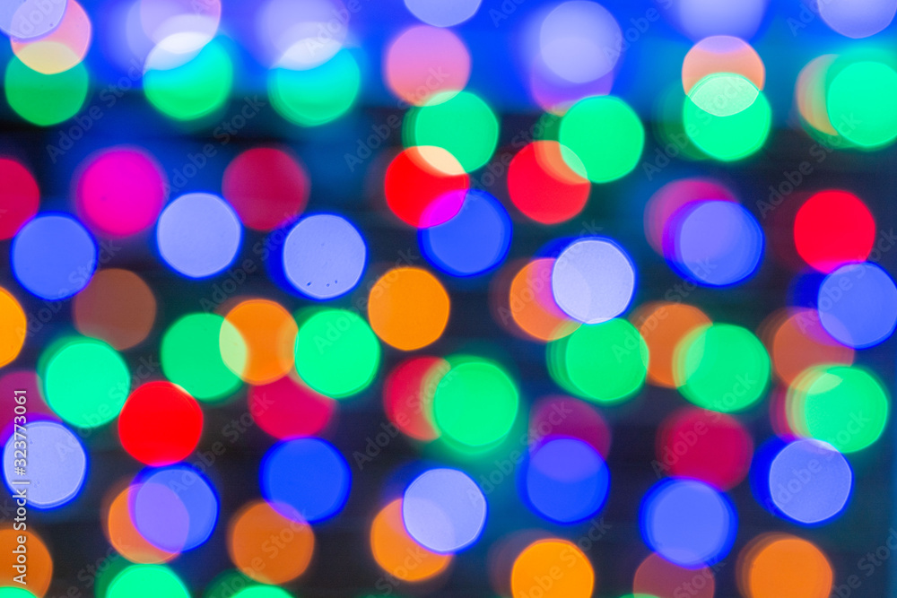 Beautiful bokeh in the form of medium-sized multicolored circles against a dark background
