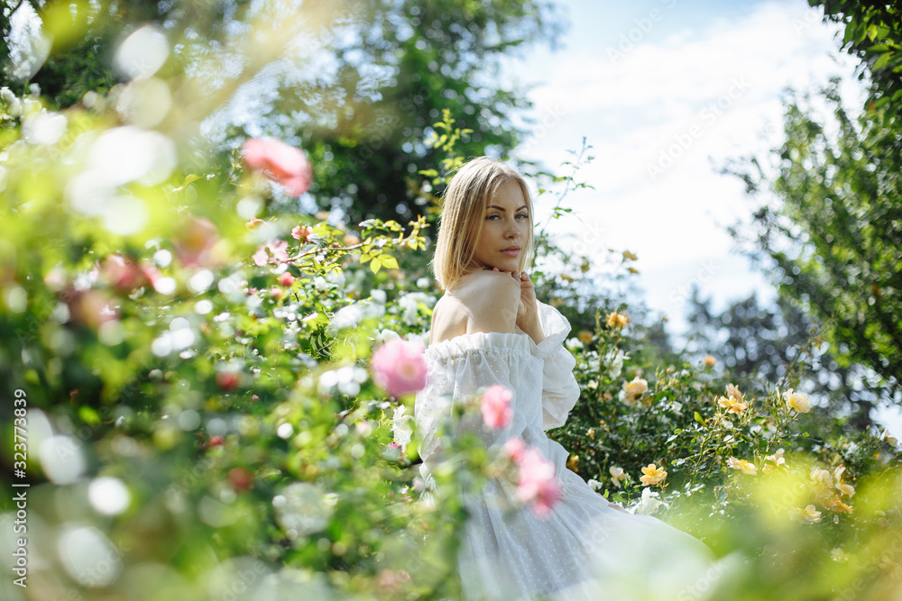 girl in a white dress in the garden with white roses
