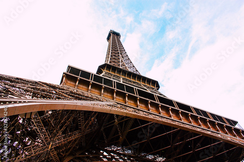 Magestuosa Torre Eiffel vista desde abajo y encuadrada con el cielo de Paris, donde su metal se ve sobrio y brillante photo