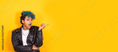 urban hipster girl isolated on color background pointing astonished