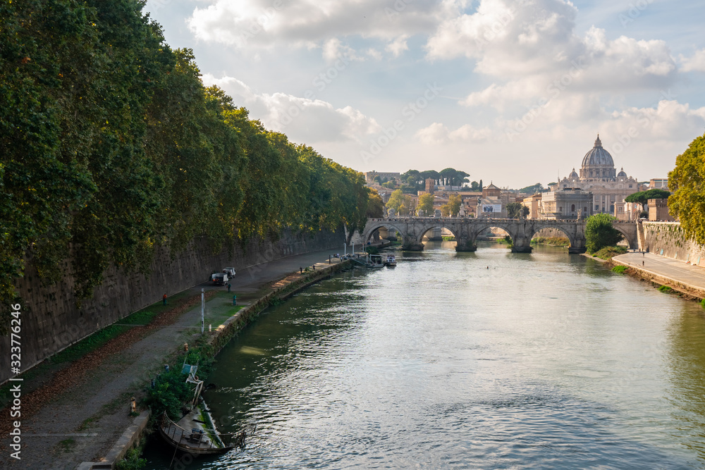 St. Peter's cathedral over bridge and Tiber river water at autumn day Rome