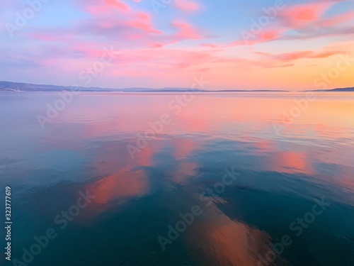 Tender pink sunset at the sea, pink flower reflection on the sea