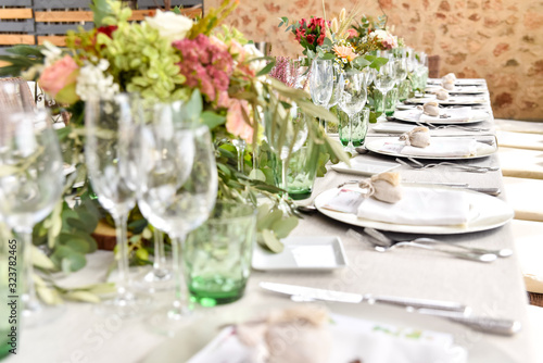 Detail of a table in a restaurant decorated for a wedding with a cutlery and tablecloths in vintage style.