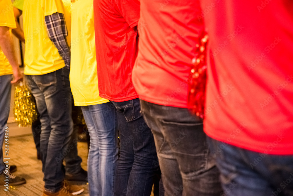 Group of back people with yellow and red colored pom poms. Group of back people with yellow and red colored pom poms.