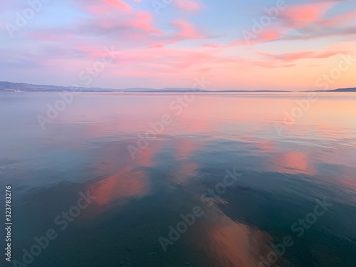 Tender pink sunset at the sea  pink flower reflection on the sea