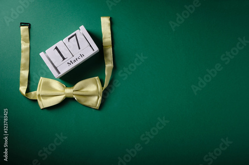 Wooden calendar with the date March 17, St. Patrick's Day, place for an inscription, green bow tie