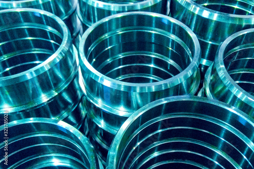 Metal parts machined on a lathe spread out on a dark background. Machined Industrial Parts. Abstract technical background for the project and design.