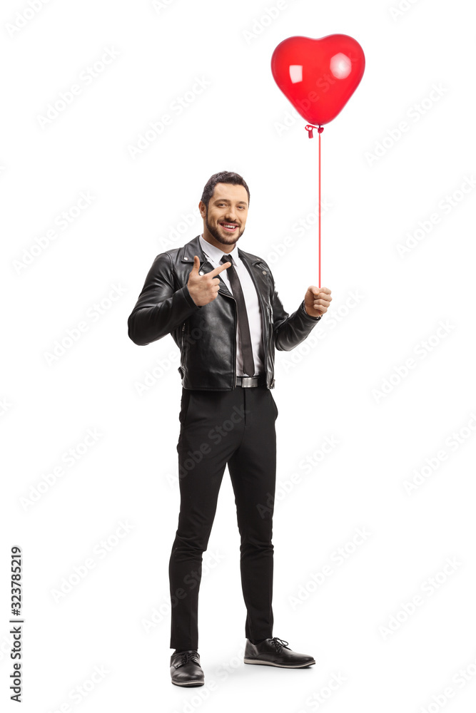 Young trendy man holding a red heart balloon and pointing Young trendy man holding a red heart balloon and pointing