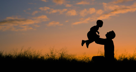 Happy father playing with his son holding him up in the air. Father son relationship concept. 