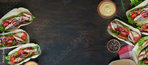 Tacos with chicken and vegetables close-up on a wooden background. Mexican dish. Food Banner. Cooking. Table background menu. Copy space.