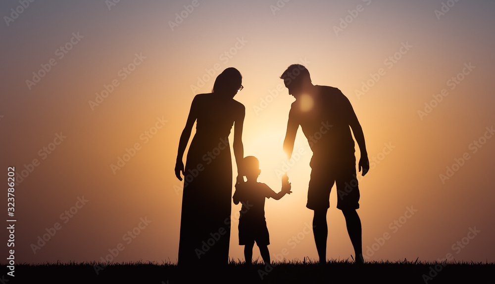 Mother, father, child walking together at sunset. Happy loving family, parenting concept. 