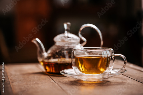 Cup of hot tea with rock sugar, dry tea leaves served in thermo glass tea cup