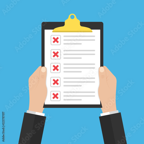 in hand document or checklist with red crosses.