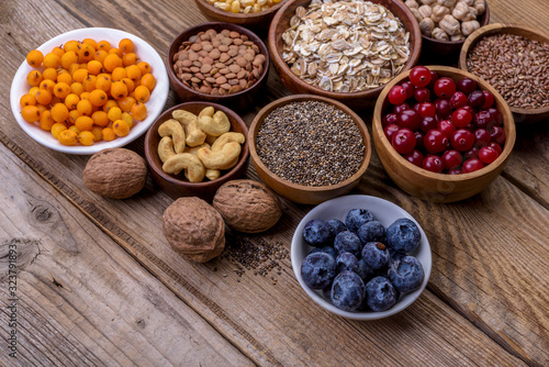 Different superfoods set, seeds, nuts,  grains, cranberries, dried apricots, sea buckthorn, blueberries, oatmeal. Vegetarian healthy diet concept.