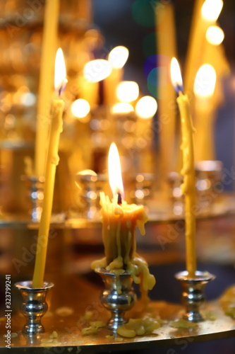 The Orthodox Church. Christianity. Many burning candles in candlesticks during liturgy in the Orthodox Church.