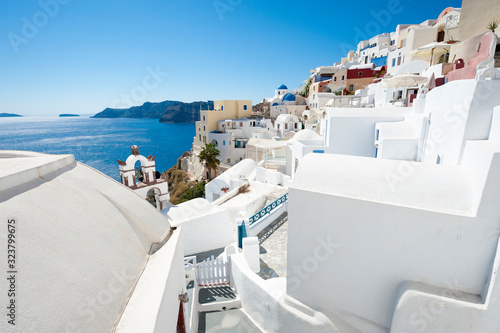 Classic Santorini staircases wind their way along bright morning hillside view of Oia village