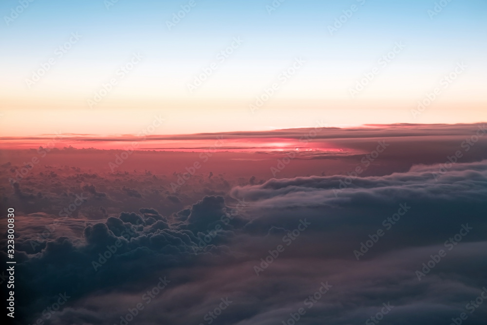 Sunset above the clouds. The view of the sunset from the plane. Rays of the sun through the clouds. Выделите текст, чтобы посмотреть примеры