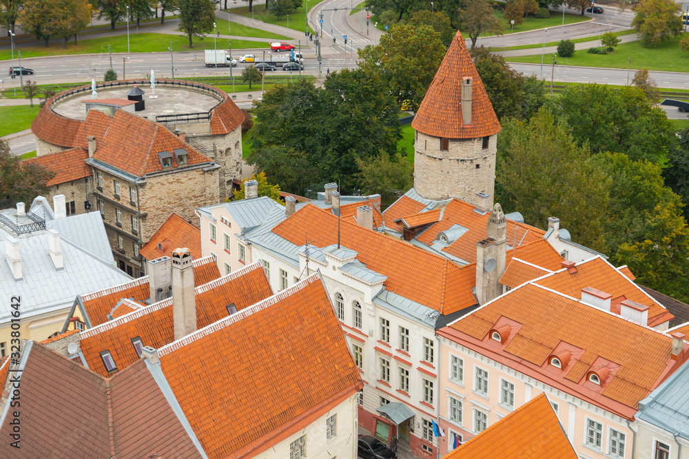 Historic city of Tallinn, medieval buildings, towers, red rooftops in the old town seen from the tower of St. Olaf's church. Sightseeing on a cloudy autumn day. Top travel destination Estonia, Europe.
