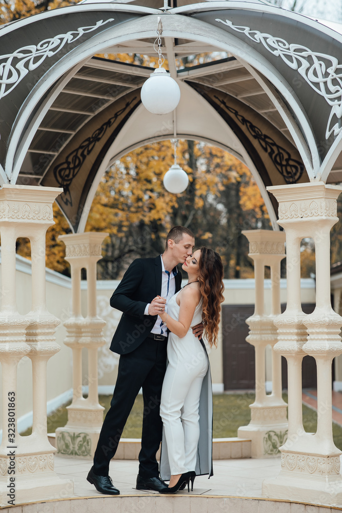 Cute young happy couple in love. Enjoy a moment of happiness and love. Romantic couple. Young fashion couple posing in the gazebo.