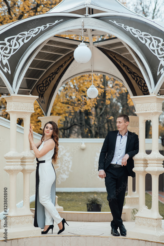 Couple posing in the gazebo. Young couple in love outdoor. Young stylish fashion couple posing. Couple posing in the gazebo. Young couple in love outdoor. Young stylish fashion couple posing.