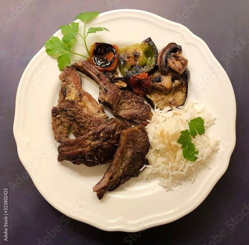 Grilled lamb chops and fresh vegetables with herbs and rice. photo