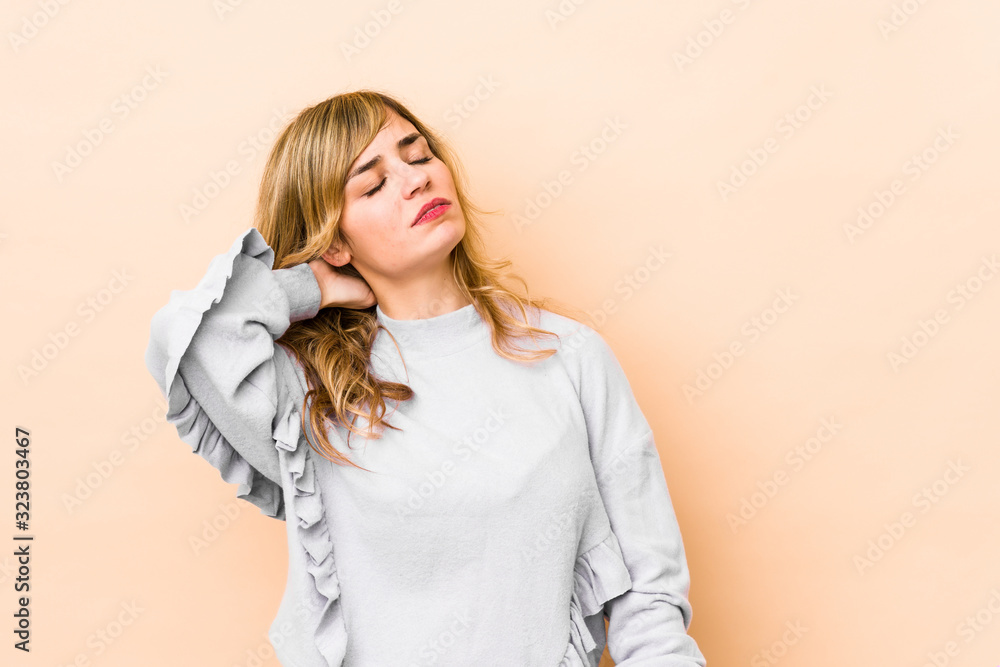 Young blonde caucasian woman having a neck pain due to stress, massaging and touching it with hand. Young blonde caucasian woman having a neck pain due to stress, massaging and touching it with hand.