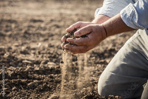 Close-up of farmer's hands picking up and inspecting soil in a plowed field. Bridger, Montana, USA photo