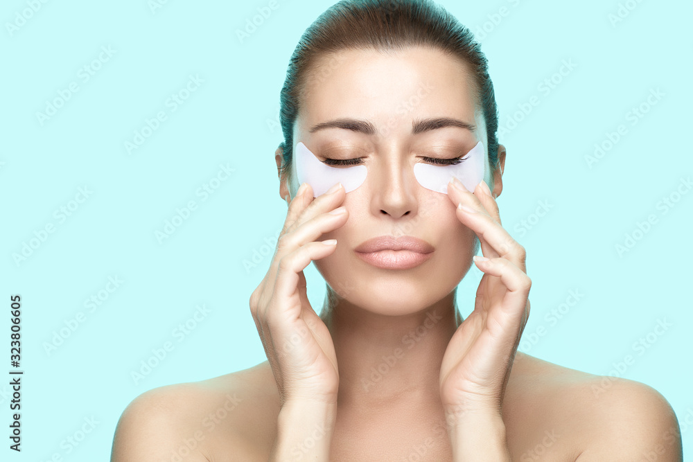 Beauty and skin care concept. Beautiful woman using pads under eyes. Eye mask