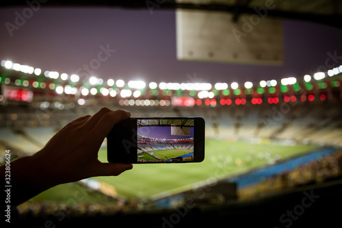 Smartphone photographing football game on the stadium photo