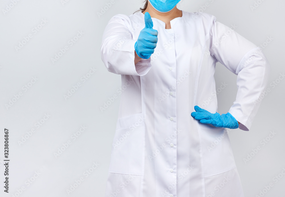 medic woman in white coat and mask, wearing blue medical latex gloves on her hands, showing like gesture in hand medic woman in white coat and mask, wearing blue medical latex gloves on her hands, showing like gesture in hand