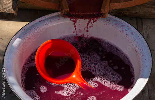 Wine making. Juice is merged from special equipment. Technology of wine production in Moldova. The ancient folk tradition of grape processing. Viticulture. photo