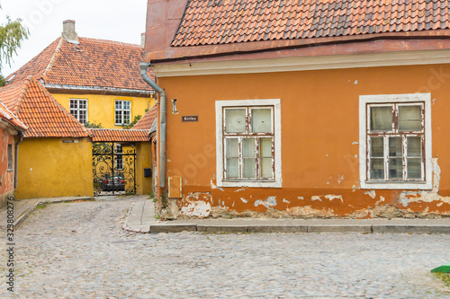 Orange houses on intersection of Toom-Kooli and Kiriku streets in Tallinn. The area near Toomkirik in old town on Toompea hill is interesting for tourists in Estonia. Road is paved with cobblestones 