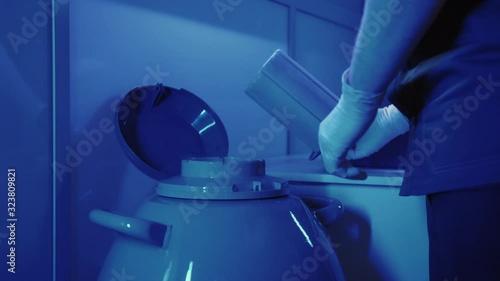 Specialist Embryologist Takes a capsule With Embryos from the Cryobank
