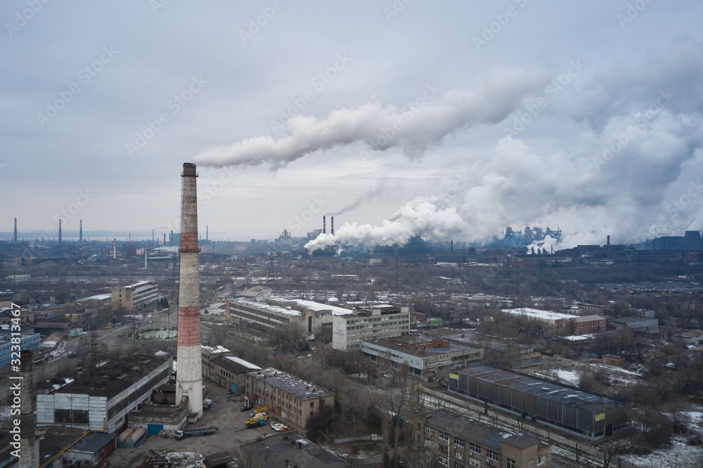 Obraz premium Aerial view of factory pipes throwing hazardous emissions into the air.