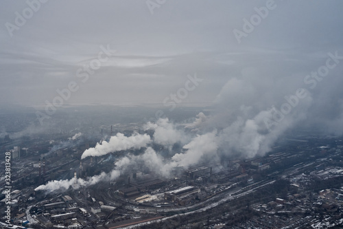 Aerial view of factory pipes throwing hazardous emissions into the air. © maksym