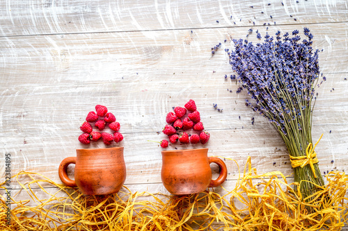 laveder composition with jar, cup, raspberry on rustic background top view mock-up photo