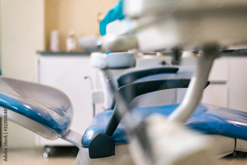 Fototapeta premium dentist's chair, side view, blue with white background and instrument table