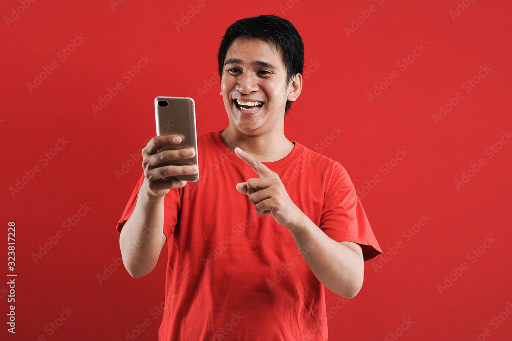 Happy Asian man reading new text on mobile Happy Asian man reading new text on mobile