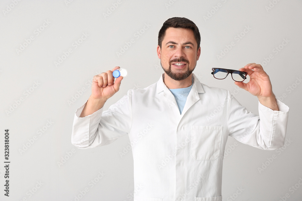 Ophthalmologist with contact lenses and glasses on light background Ophthalmologist with contact lenses and glasses on light background