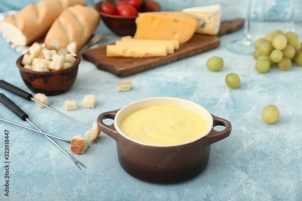 Cheese fondue with snacks on color background Cheese fondue with snacks on color background