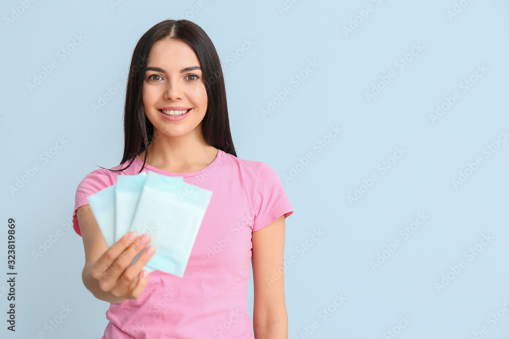 Young woman with menstrual pads on color background Young woman with menstrual pads on color background
