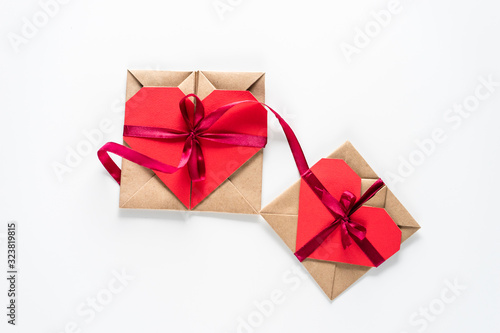 two Hart shaped paper gift cards tied with red ribbon on the white background top high angle view