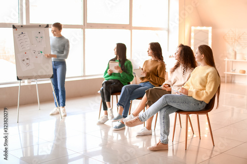 Young woman teaching students in makeup school