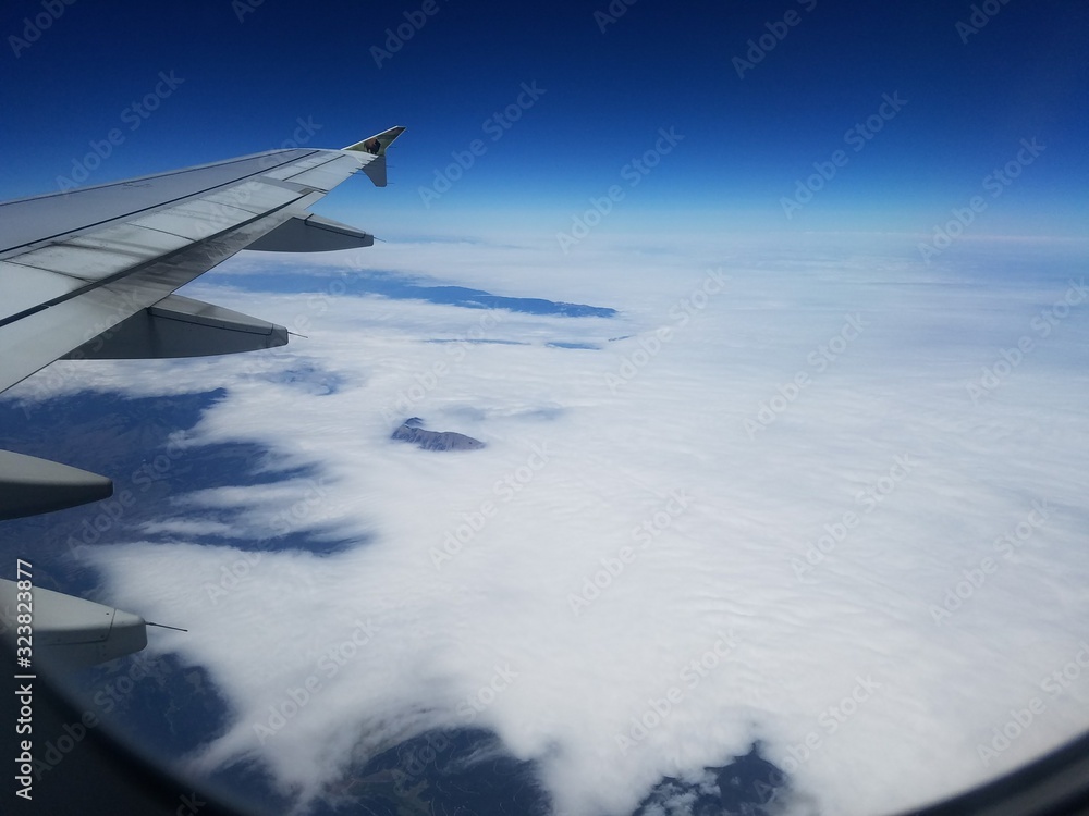 wing of an airplane flying above the clouds wing of an airplane flying above the clouds