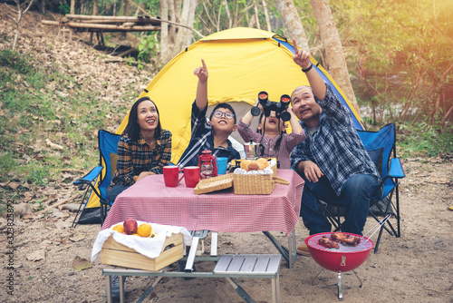 Happy Family Asian Enjoying picnic and Camping Holiday In Countryside