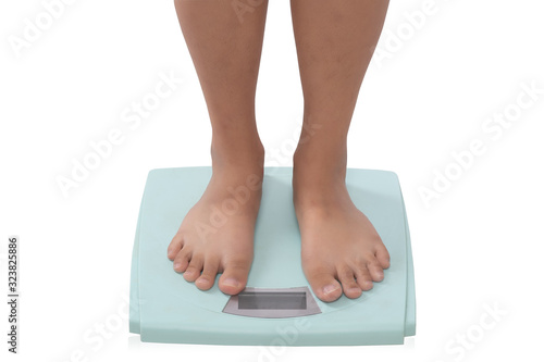 Close up partial view of young woman standing on digital scales isolated on white background. Weight loss concept.