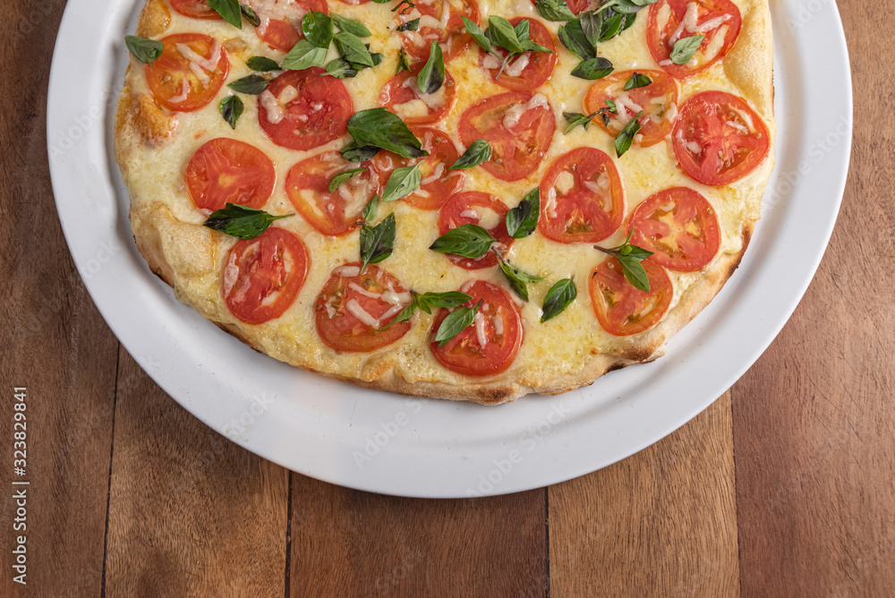 Pizza on the brown wooden table Pizza on the brown wooden table