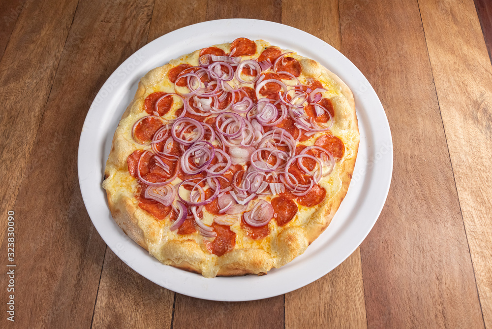 Pizza on the brown wooden table Pizza on the brown wooden table